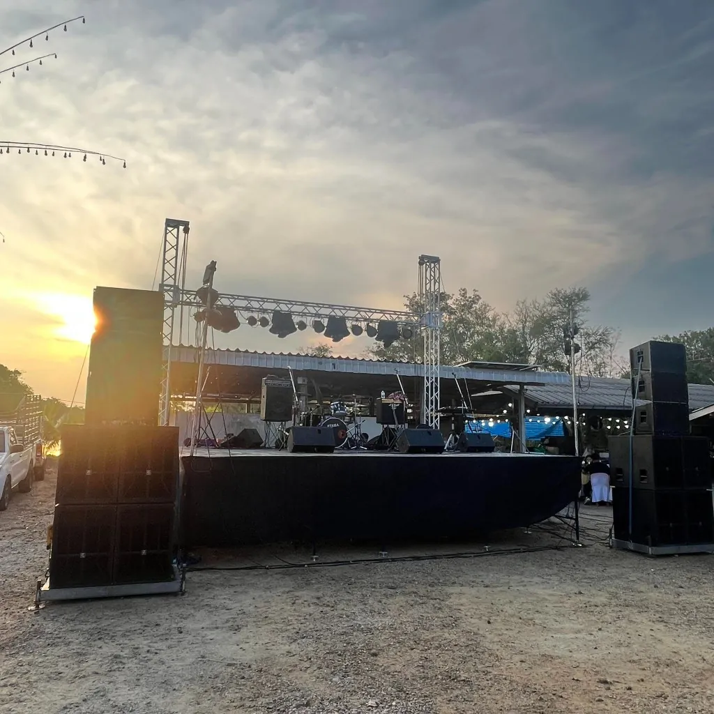เวทีกลางแจ้งของร้านต๋องเวทีซิ่งยามเย็น มีลำโพงสองข้าง ไฟบนโครงทรัส และกลองบนเวที