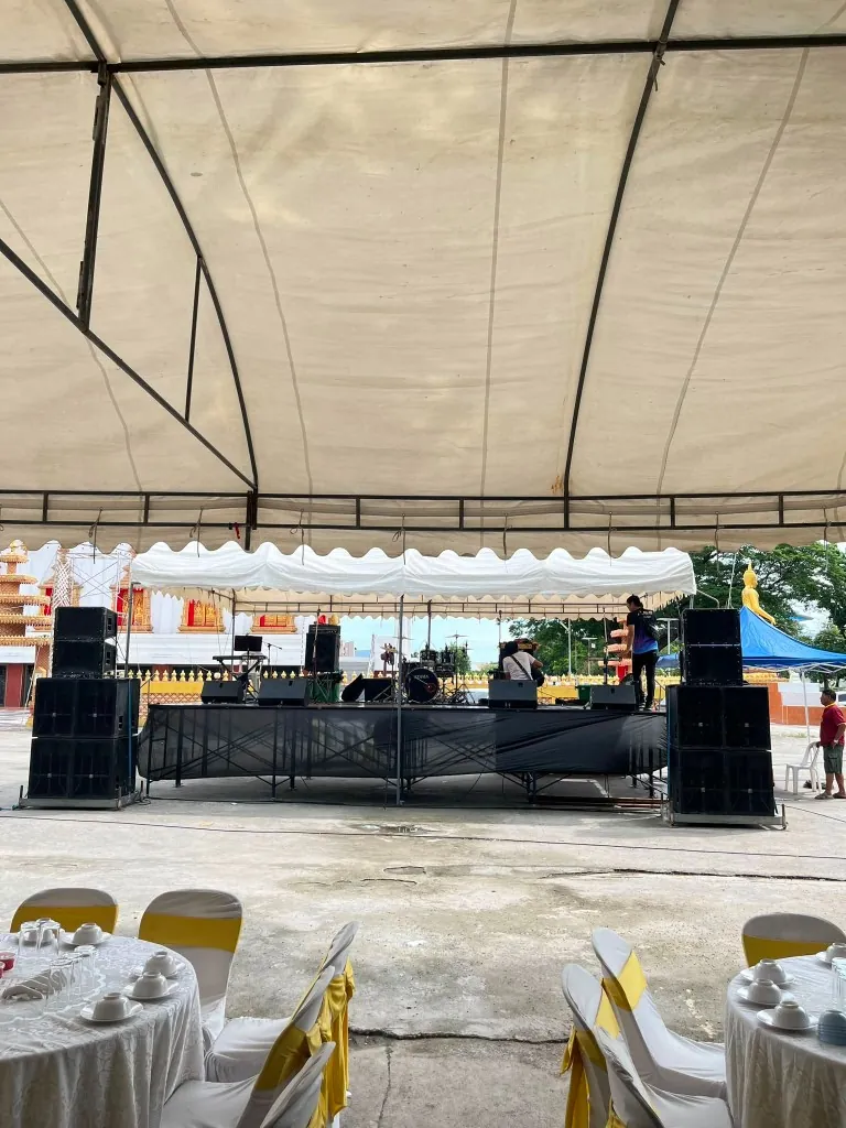 เวทีในเต็นท์งานพิธีของร้านต๋องเวทีซิ่ง มีลำโพงสองข้าง กลอง และโต๊ะจีนด้านหน้า